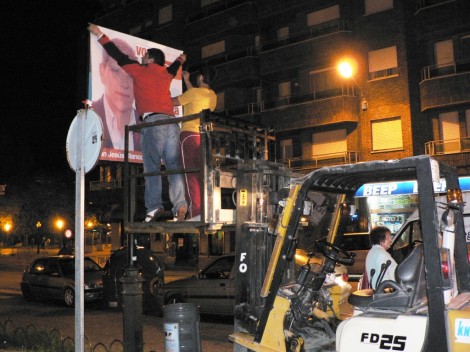 Un miembro del PP coloca un cartel retirado de los tendidos.