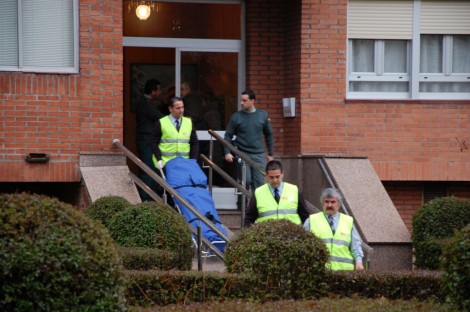 Los empleados de la funeraria sacan del edificio el cadáver de Iván Llavador.