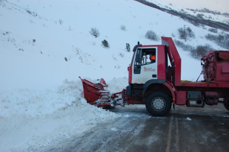 Una maquina retira la nieve de la carretera de Velillaal límite con León